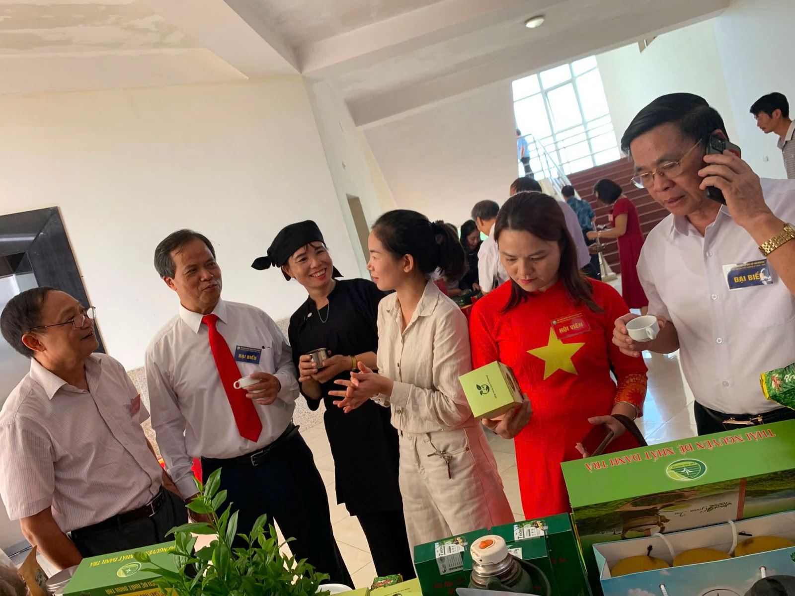 Đại biểu chụp ảnh lưu niệm tại bàn trưng bày sản phẩm nông sản của các HTX/DN là hội viên